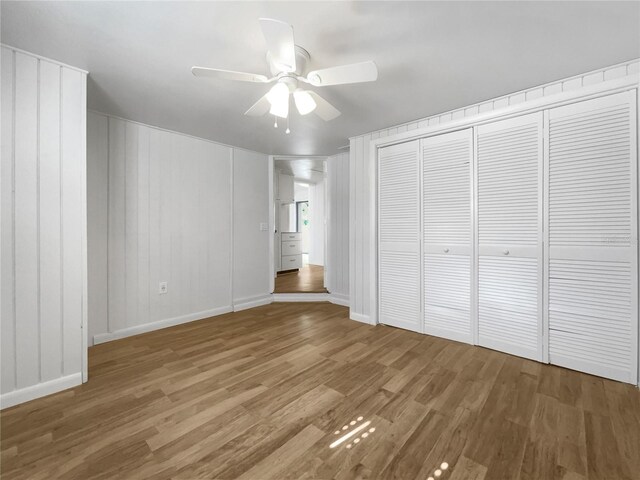 unfurnished bedroom with wood-type flooring, ceiling fan, and a closet