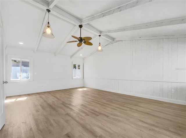 unfurnished room featuring hardwood / wood-style flooring, ceiling fan, and lofted ceiling with beams