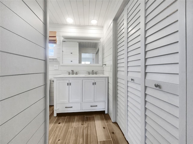 bathroom featuring vanity, wood-type flooring, and wood walls