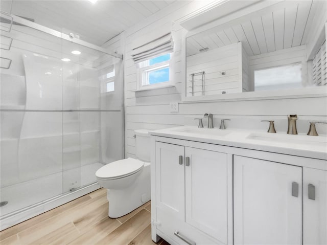 bathroom with vanity, wood-type flooring, a shower with door, and toilet