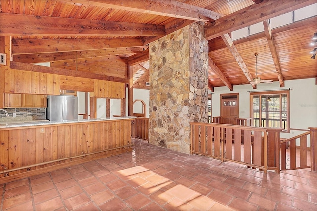 kitchen with stainless steel refrigerator, lofted ceiling with beams, backsplash, kitchen peninsula, and wooden ceiling