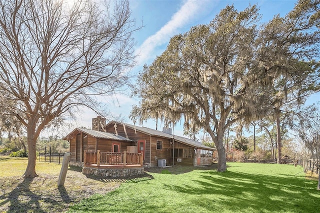 rear view of property with a wooden deck, central AC unit, and a lawn