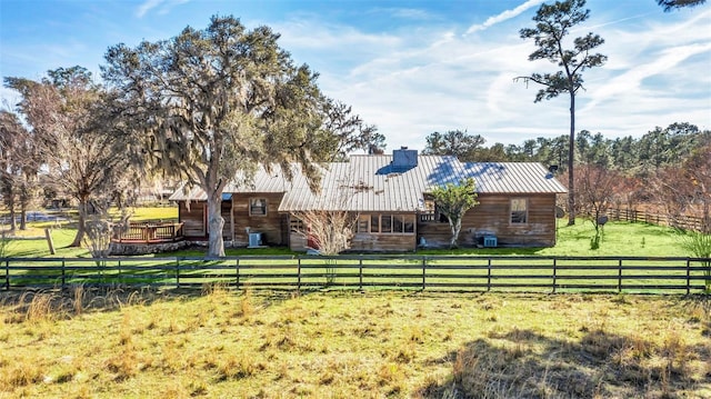 back of house featuring a yard and a rural view