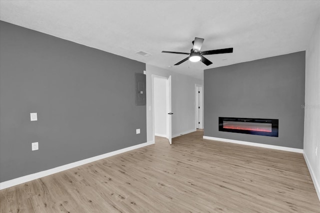 unfurnished living room featuring ceiling fan, light hardwood / wood-style floors, and electric panel