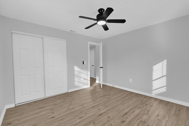 unfurnished bedroom with ceiling fan, a closet, and light hardwood / wood-style flooring