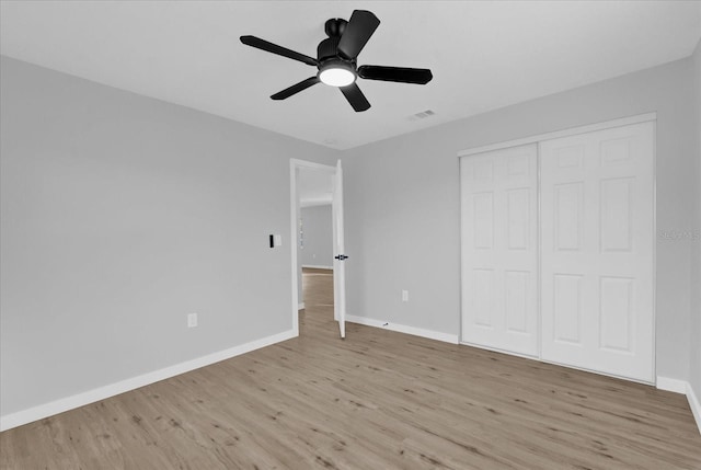 unfurnished bedroom featuring ceiling fan, light hardwood / wood-style floors, and a closet