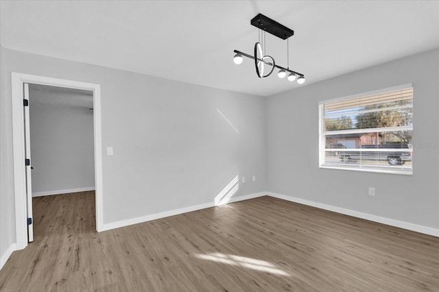 unfurnished dining area with light hardwood / wood-style floors and a notable chandelier