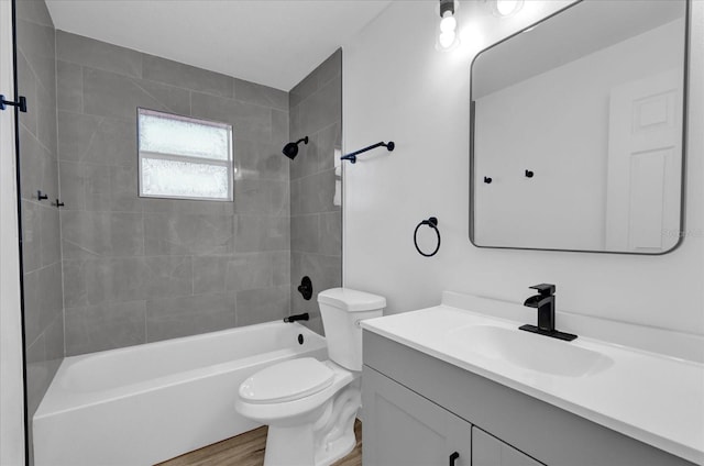 full bathroom with vanity, wood-type flooring, toilet, and tiled shower / bath