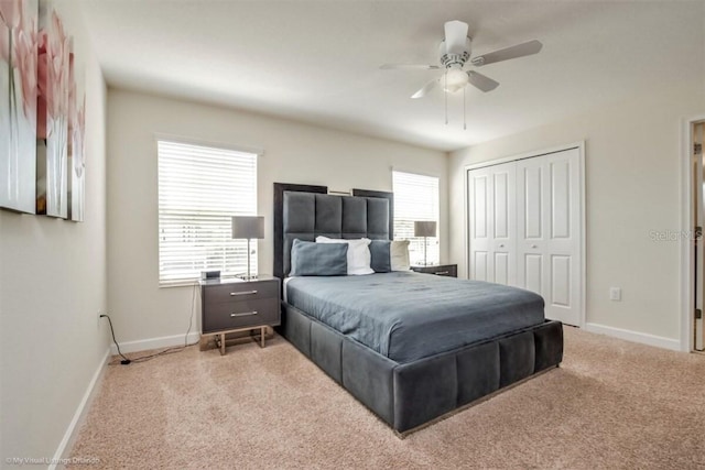 carpeted bedroom with ceiling fan and a closet