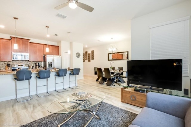 living room with ceiling fan and light hardwood / wood-style floors