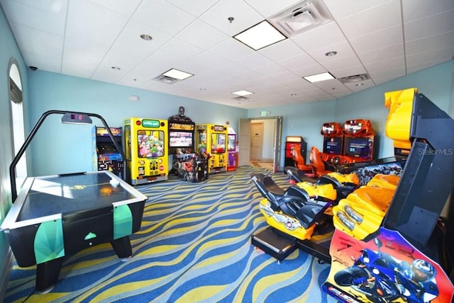 recreation room with a paneled ceiling and carpet floors