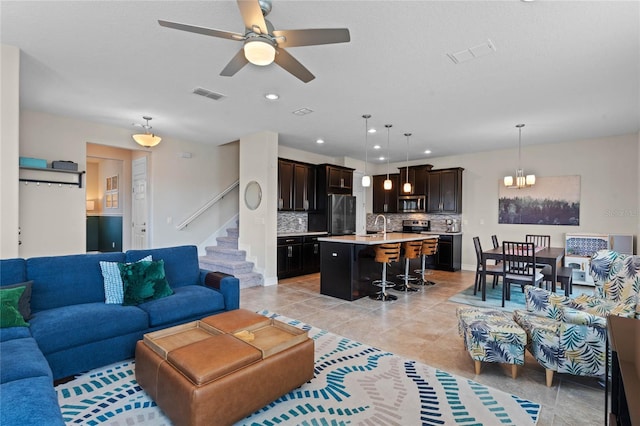 living room featuring light tile patterned floors, sink, and ceiling fan