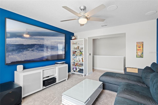 carpeted living room with ceiling fan and a textured ceiling