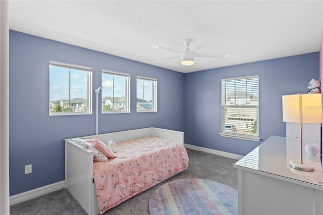 carpeted bedroom featuring multiple windows and ceiling fan