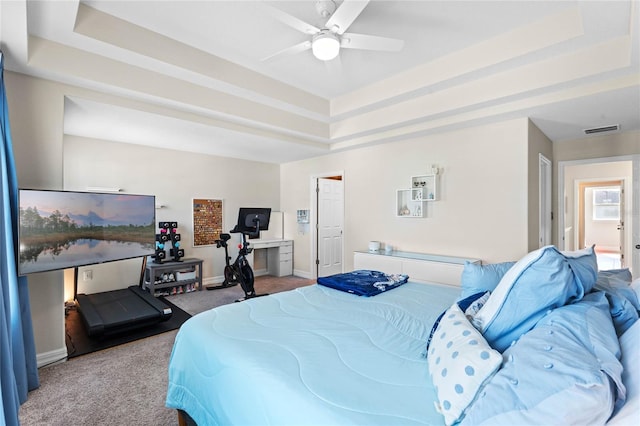 bedroom featuring ceiling fan, a raised ceiling, and carpet