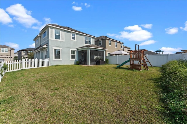 back of house with a yard, a sunroom, and a playground