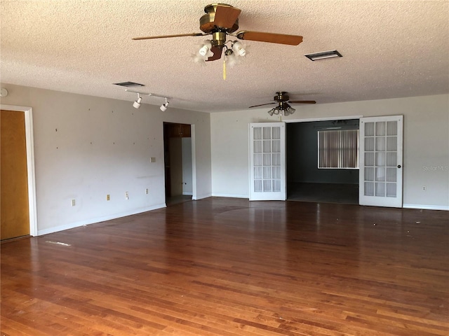 spare room with ceiling fan, dark hardwood / wood-style floors, a textured ceiling, and french doors