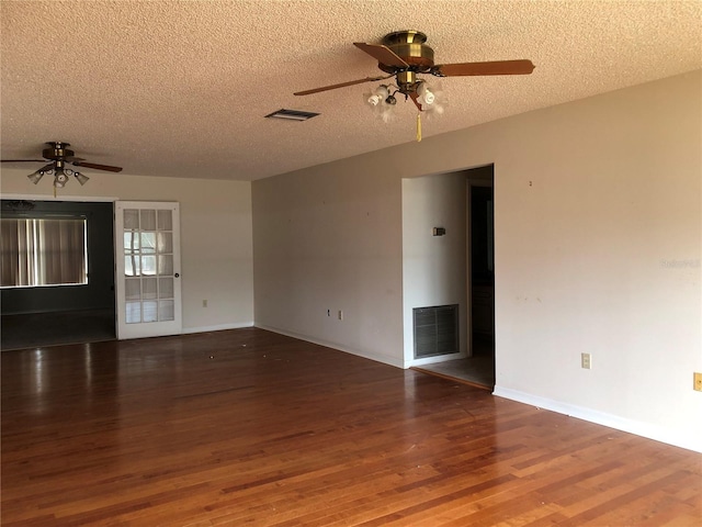 spare room featuring dark wood-type flooring, ceiling fan, and a textured ceiling