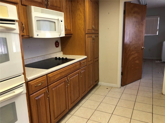 kitchen with light tile patterned flooring and white appliances