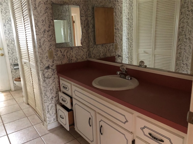 bathroom with tile patterned flooring, vanity, and toilet