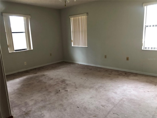 unfurnished room with a healthy amount of sunlight and light carpet