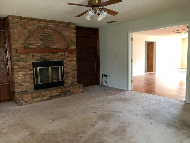 unfurnished living room with ceiling fan, a fireplace, and a textured ceiling