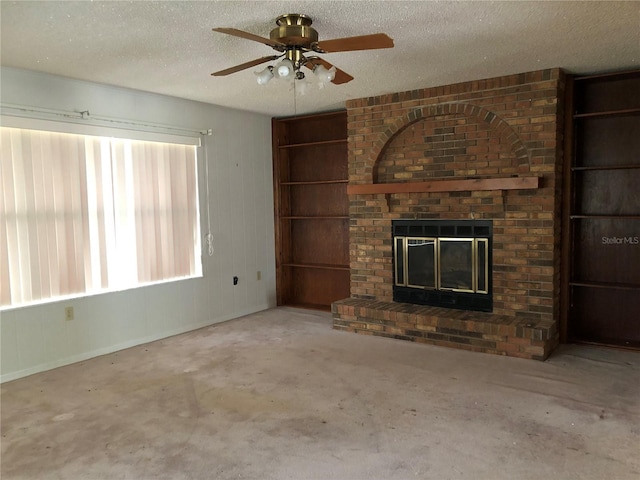 unfurnished living room featuring concrete floors, ceiling fan, a brick fireplace, and a textured ceiling