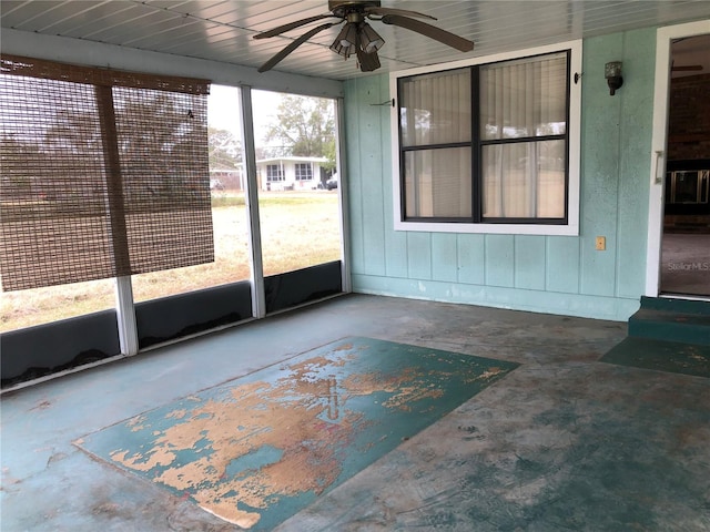 unfurnished sunroom featuring ceiling fan