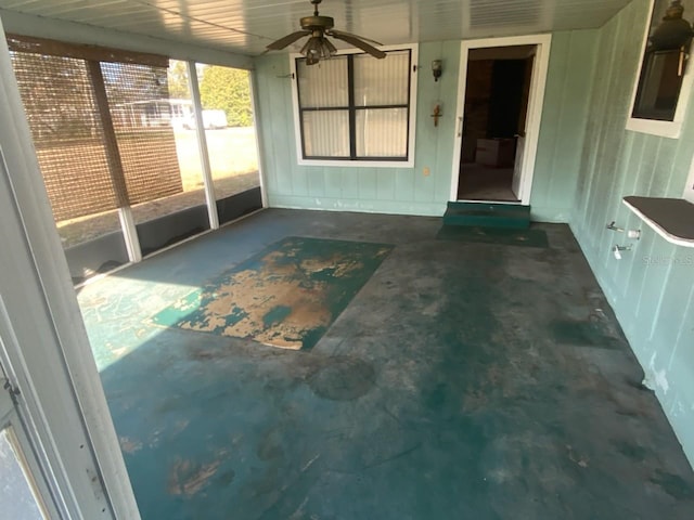 unfurnished sunroom featuring ceiling fan