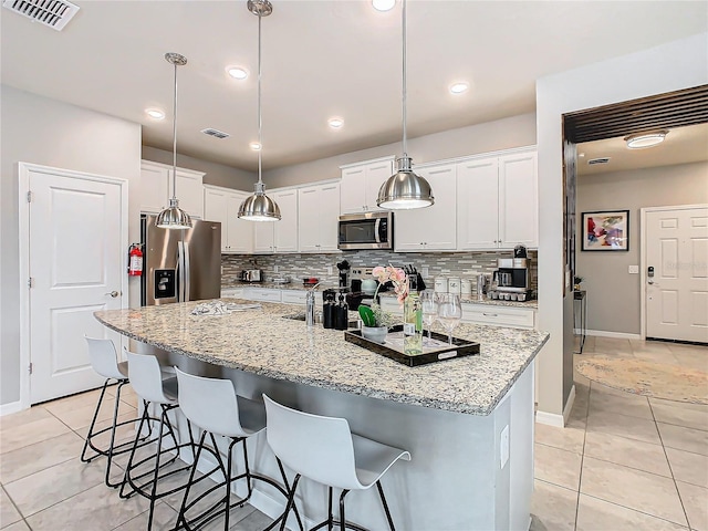 kitchen featuring white cabinetry, appliances with stainless steel finishes, and a kitchen island with sink