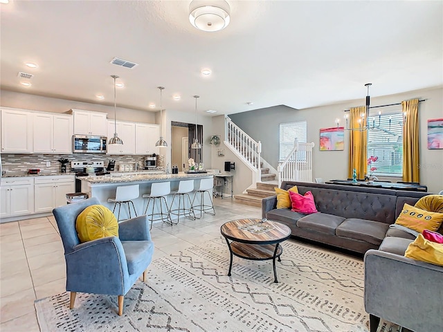 tiled living room featuring a chandelier