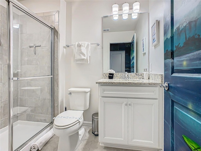 bathroom with a shower with door, vanity, and toilet