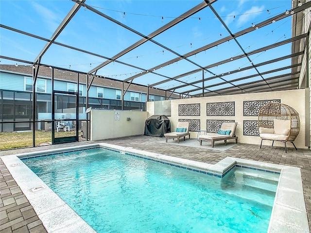 view of swimming pool featuring grilling area, a patio, and glass enclosure