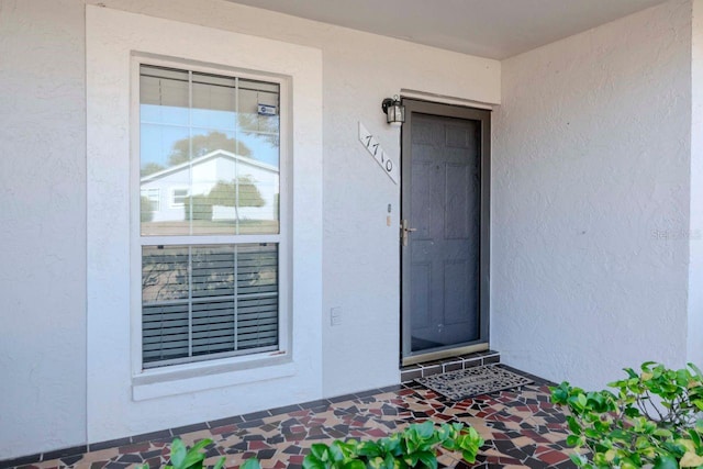 property entrance with stucco siding