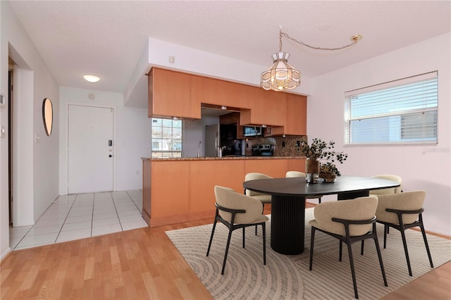 dining room with light wood-style flooring and a textured ceiling