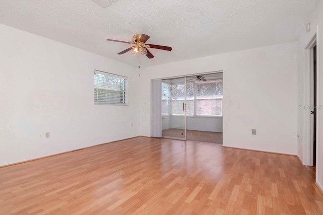 spare room with ceiling fan, light wood finished floors, and a textured ceiling