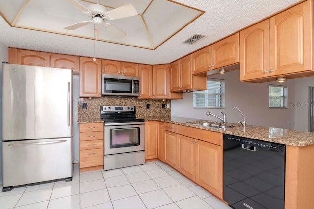 kitchen featuring light stone counters, stainless steel appliances, visible vents, a sink, and a textured ceiling