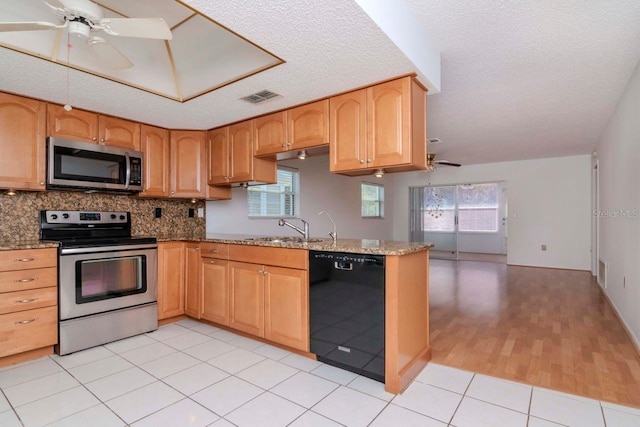 kitchen featuring stainless steel appliances, a peninsula, a sink, visible vents, and a ceiling fan