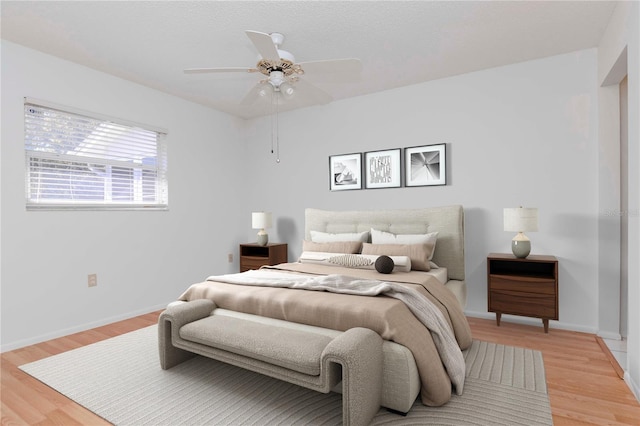 bedroom featuring light wood-type flooring, ceiling fan, and baseboards