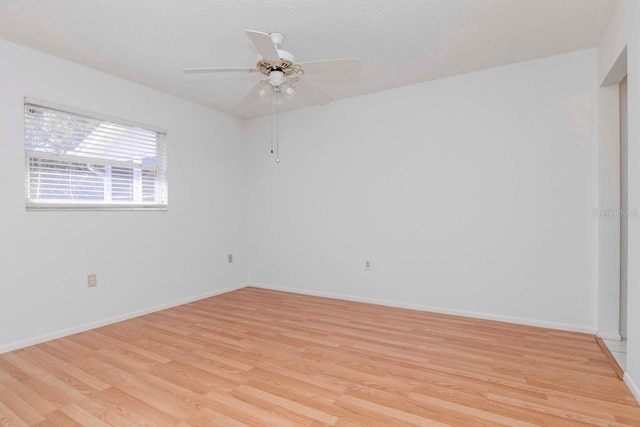 unfurnished room featuring baseboards, a textured ceiling, a ceiling fan, and light wood-style floors