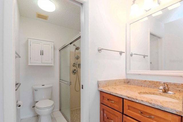 bathroom featuring a stall shower, visible vents, toilet, tile patterned floors, and vanity