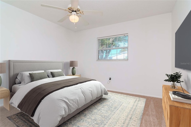 bedroom with light carpet, ceiling fan, and baseboards