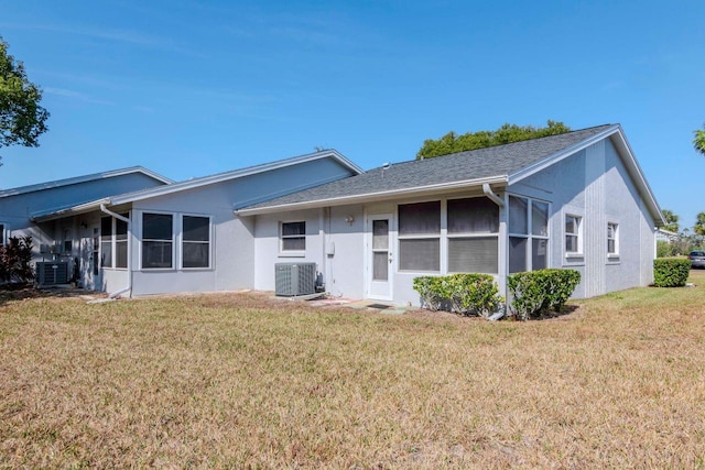 ranch-style home with a yard, cooling unit, and stucco siding