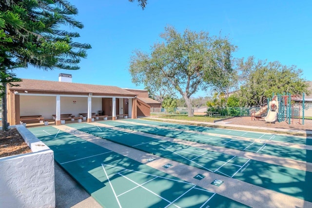 view of pool featuring playground community, fence, and shuffleboard