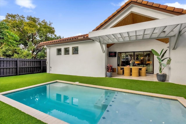 rear view of house featuring a fenced in pool, a pergola, a patio area, and a lawn