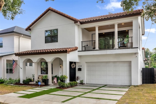 mediterranean / spanish-style home featuring a garage and a balcony