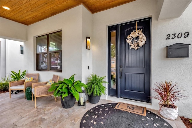 view of exterior entry featuring covered porch