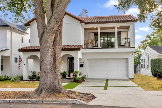 mediterranean / spanish house featuring a garage and a balcony