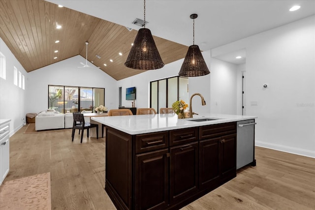 kitchen with decorative light fixtures, an island with sink, sink, stainless steel dishwasher, and dark brown cabinets