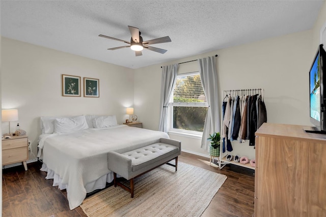 bedroom with dark wood-style floors, ceiling fan, and a textured ceiling